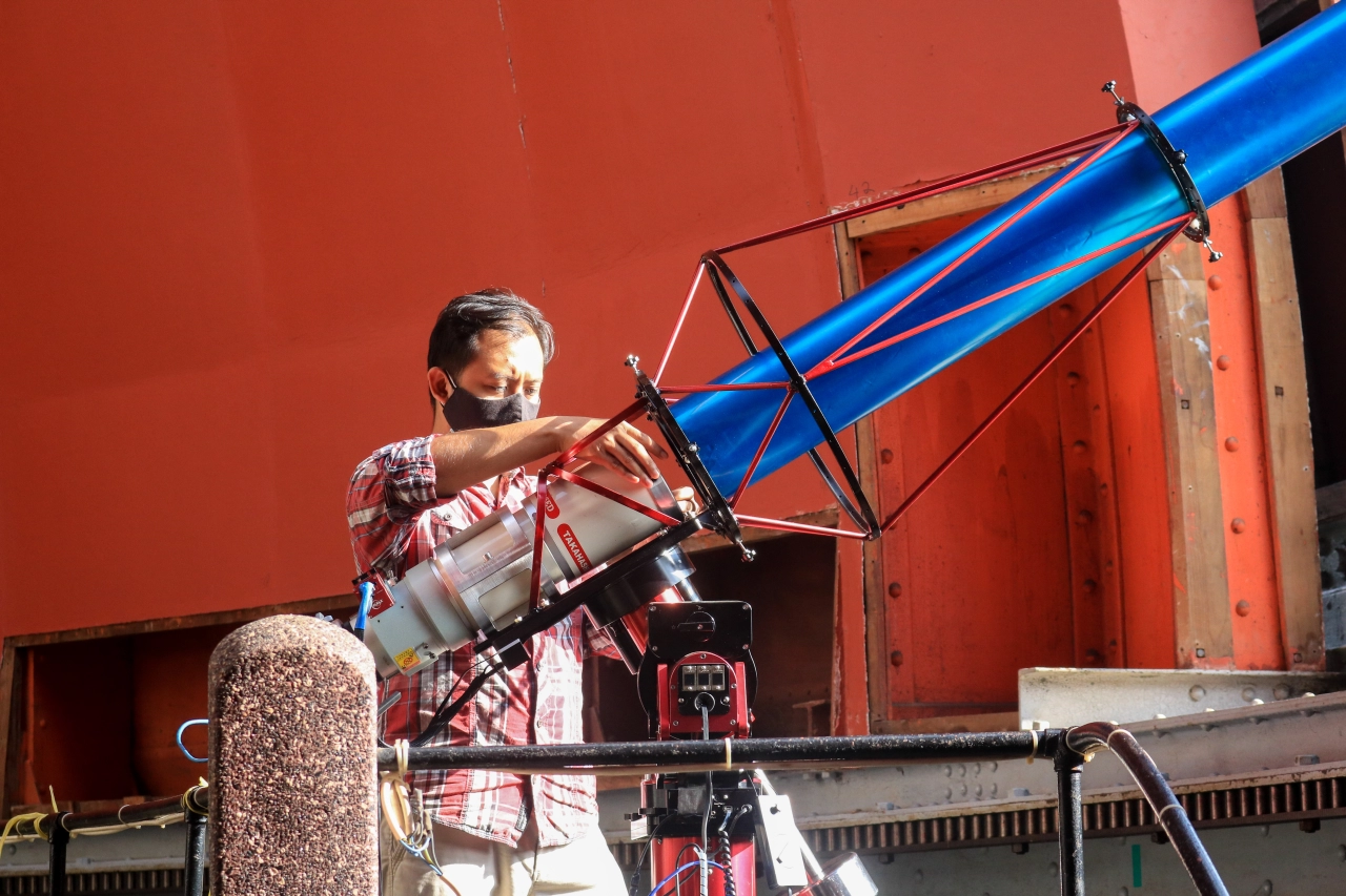 Gambar 1. Asisten peneliti, Dhimaz Gilang Ramadhan, melakukan pengecekan teleskop yang digunakan untuk pengamatan hilal. 